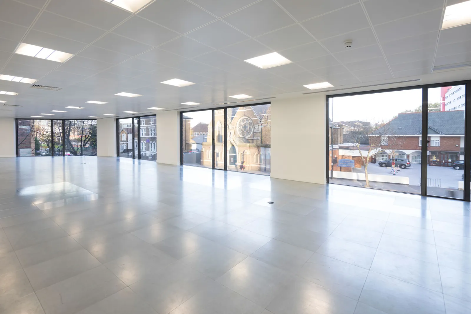 Bright, open-plan office floor with full-height windows looking out over Croydon